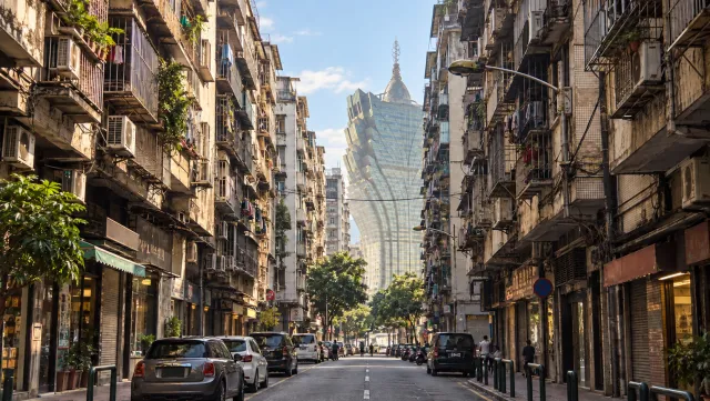Grand Lisboa rises beyond a narrow balcony-lined street in Macau