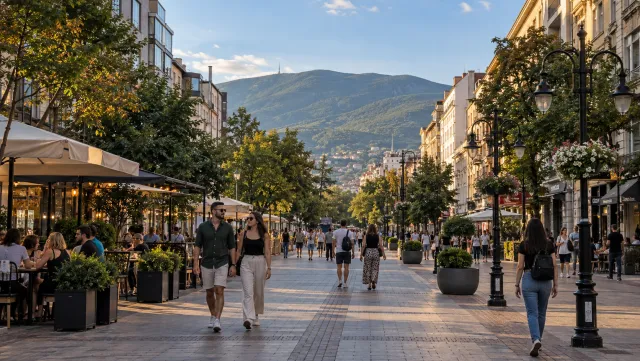 People stroll along Vitosha Boulevard in Sofia with Vitosha Mountain beyond